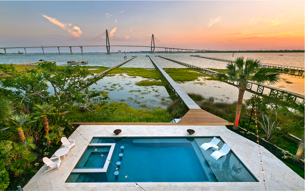 Luxurious, modern pool with an ocean view and large bridge in the background