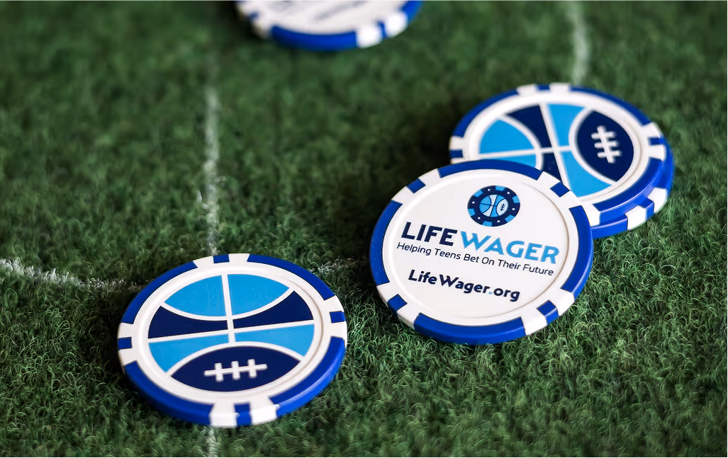 Close up view of blue and white poker chips displaying Life Wager branding