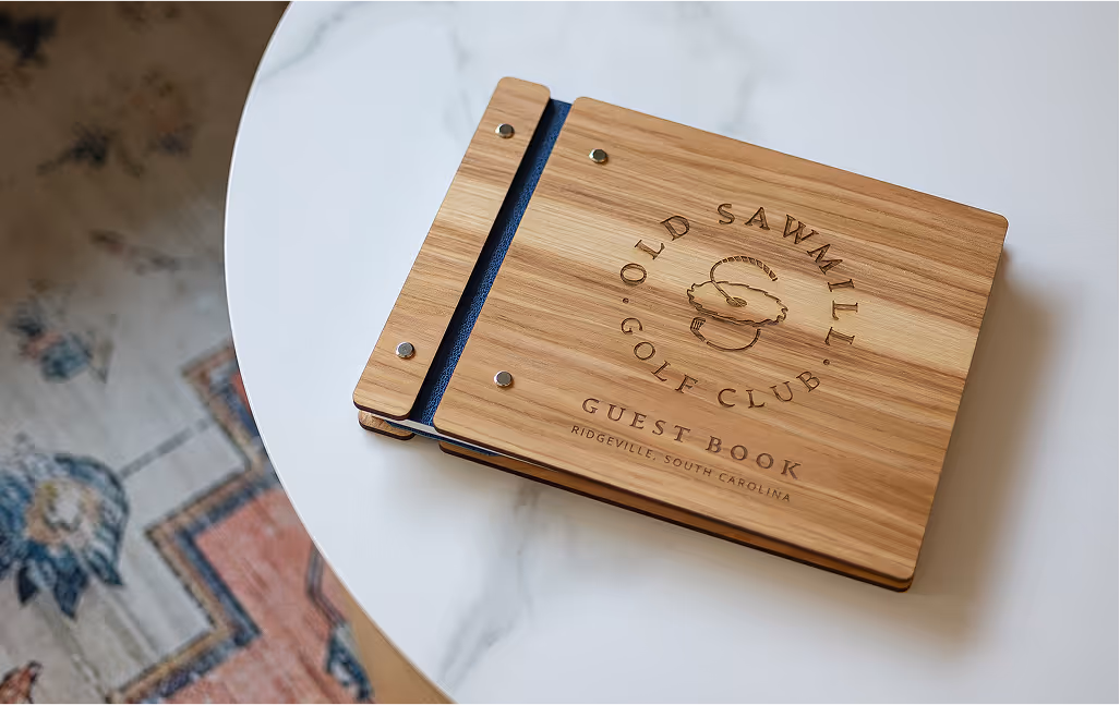Old Sawmill Golf Club guest book with branding carved into a unique light wood cover