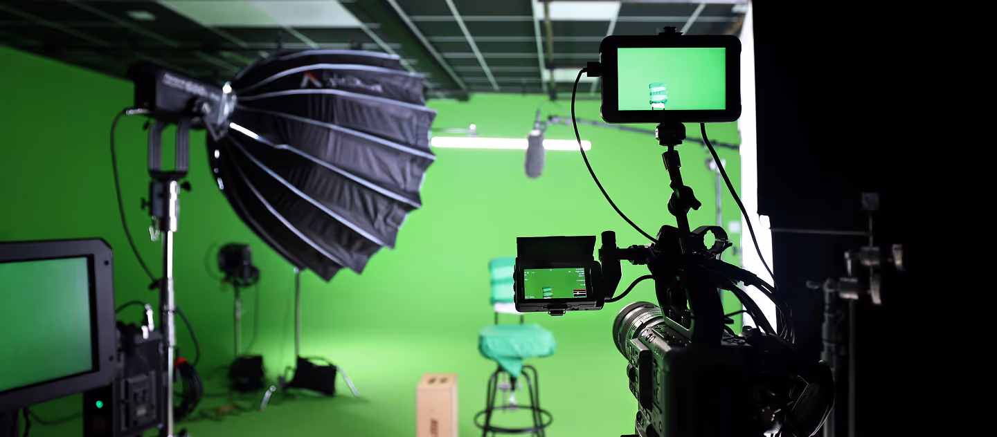 Green screen video production studio setup with camera equipment, lighting, and microphone ready for filming.