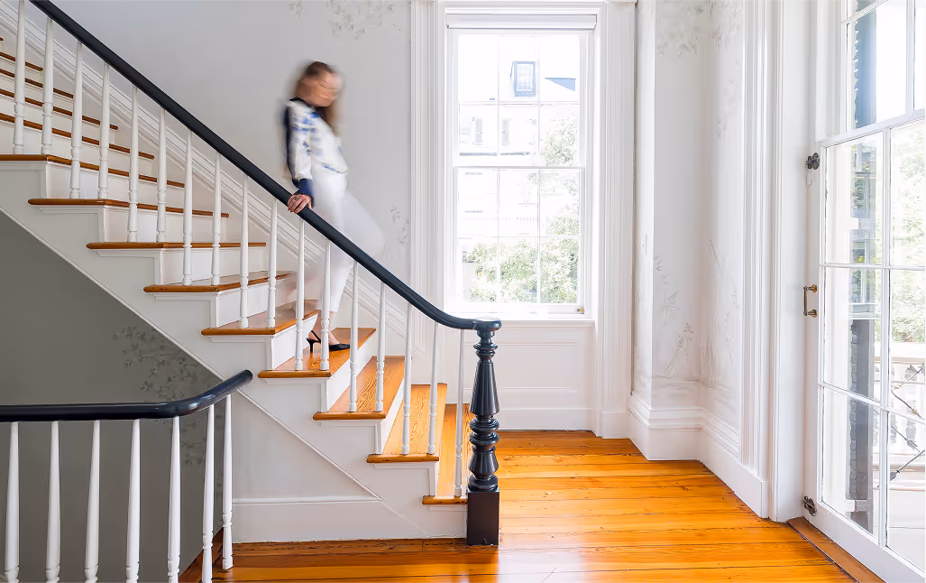 Woman walking down a classic wooden staircase