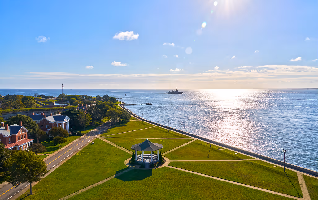Aerial view of a large grassy park on a sunny coastline