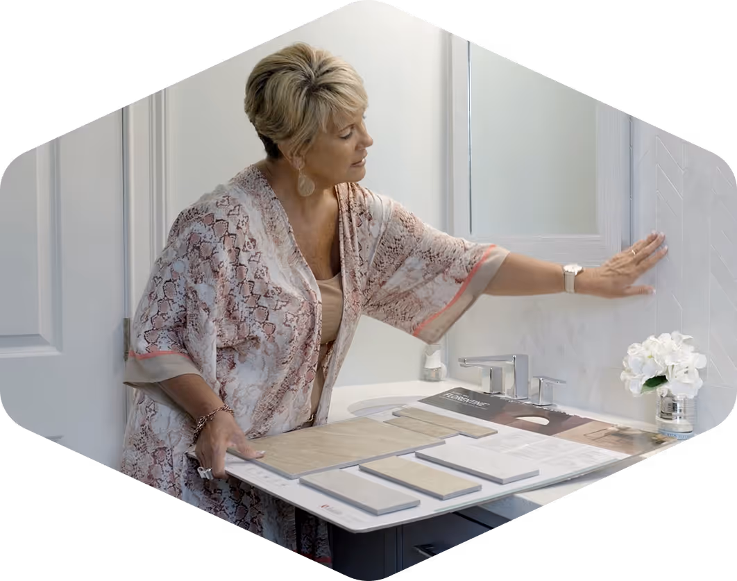 Woman reviewing tile samples and backsplash design in bathroom during mobile flooring consultation.