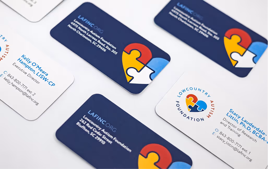 Top down view of Low Country Autism Foundation business cards assembled on a white tabletop