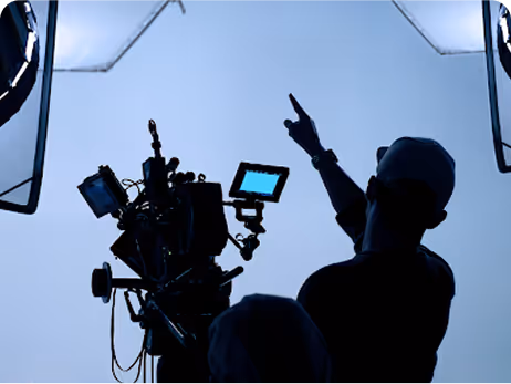 Camera operator in a professional videography studio with white backdrop walls