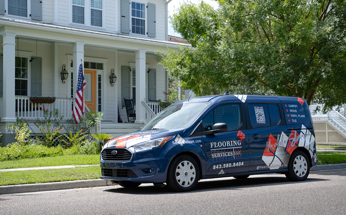 Blue Flooring Services LLC van parked in front of a large white residential home.