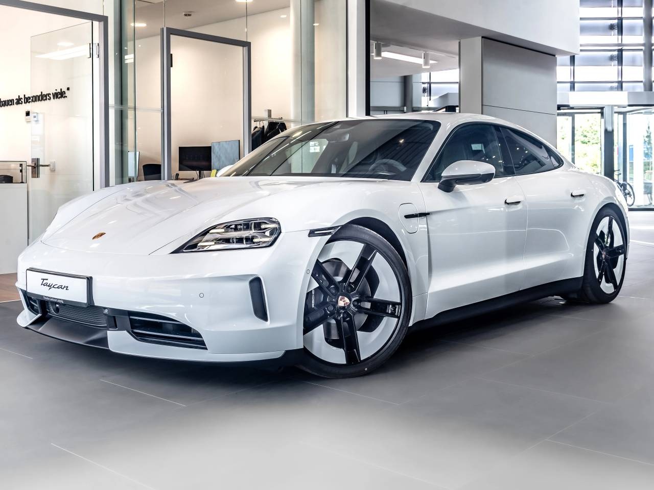 Porsche Taycan phase 2 blanche de trois quarts avant en showroom