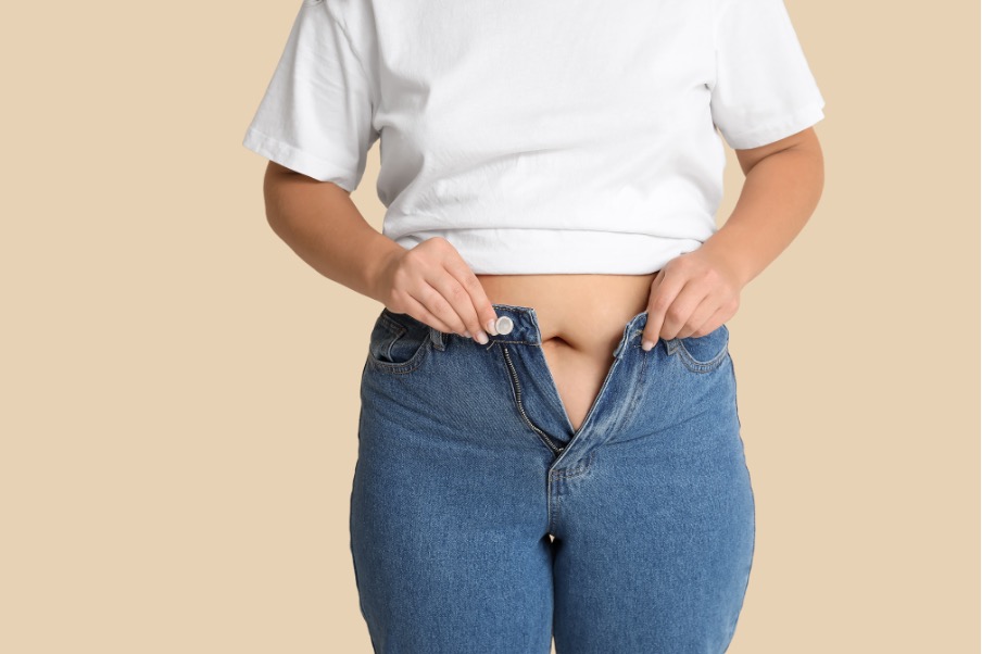 Woman unable to close jeans due to abdominal changes in menopause