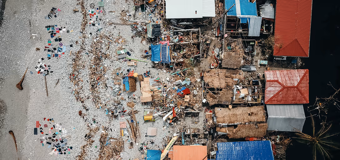 An aerial view photograph showing destroyed homes by the shoreline.