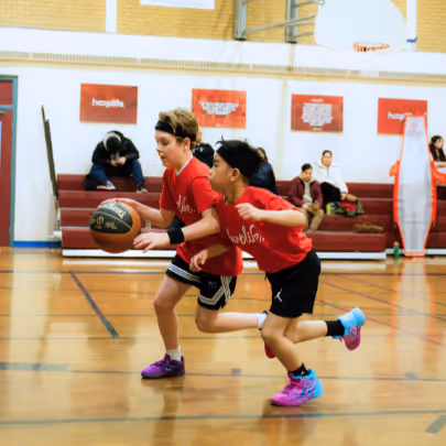 Kid running with a basketball while being chased