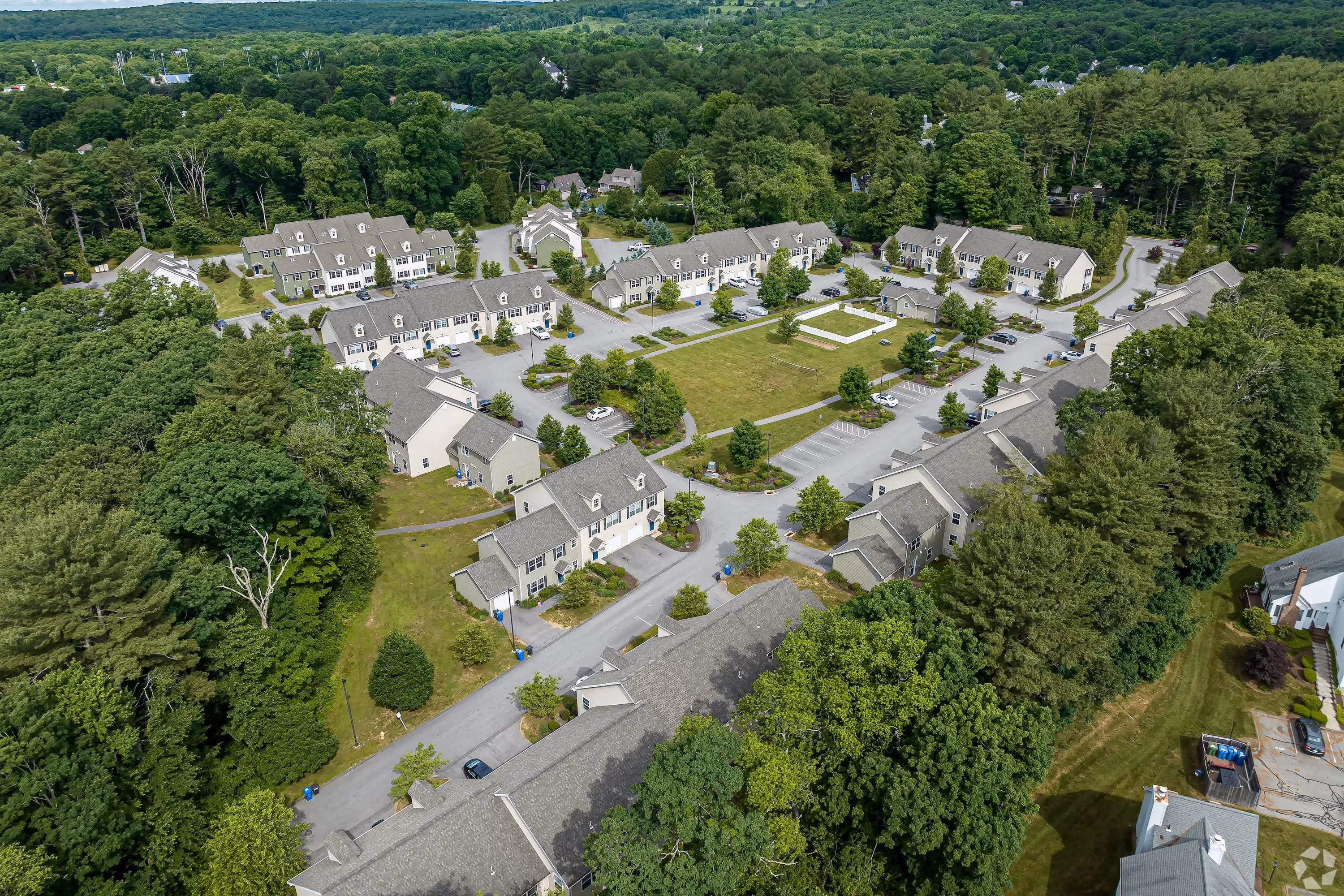 Overhead view of the Meadowbrook Gardens apartment complex in Mansfield Center, CT, showcasing multiple buildings and green spaces within the community.