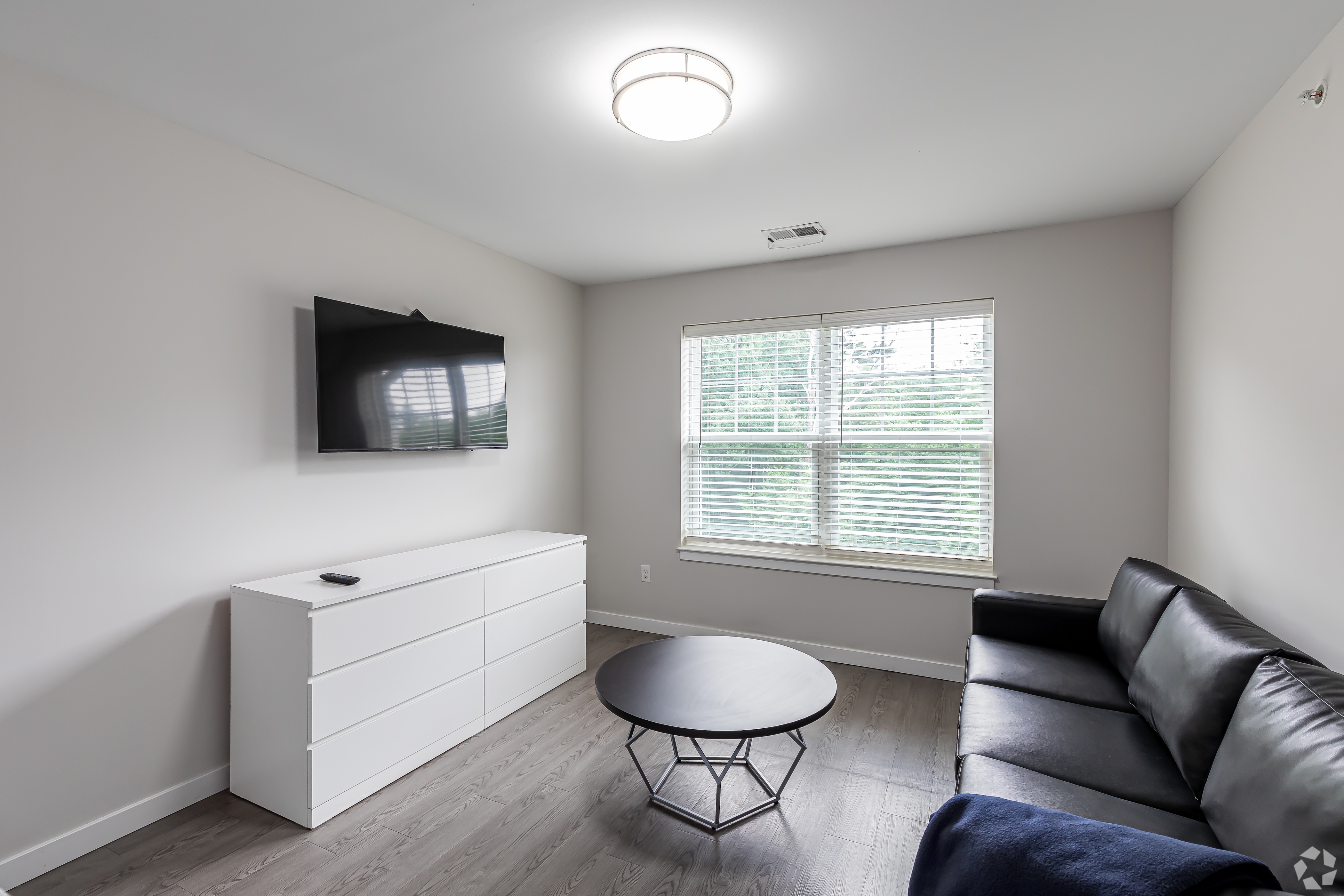 Styled and furnished living room with couch and coffee table with a tv mounted on the wall 