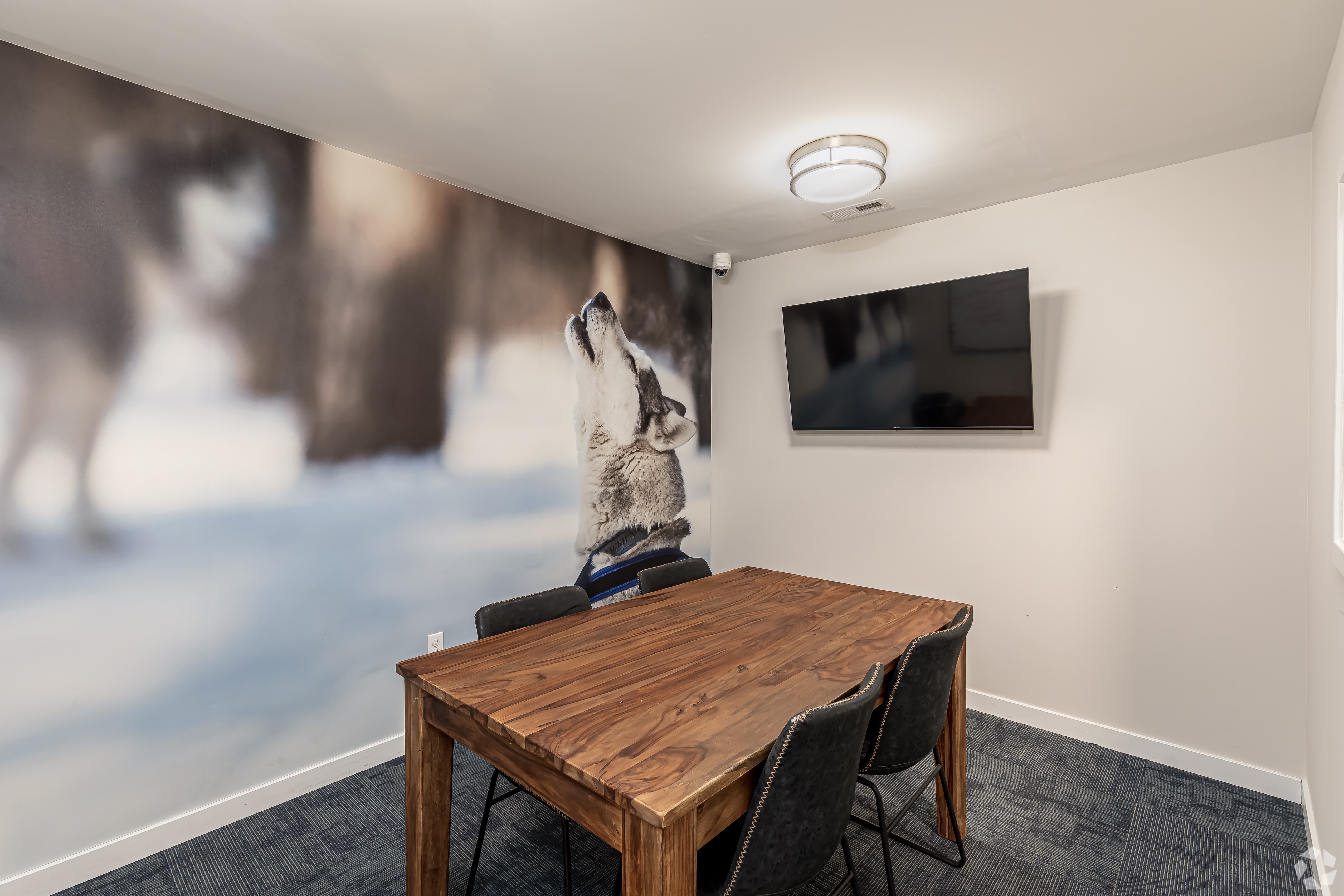 Room with table and chairs and a tv on the wall