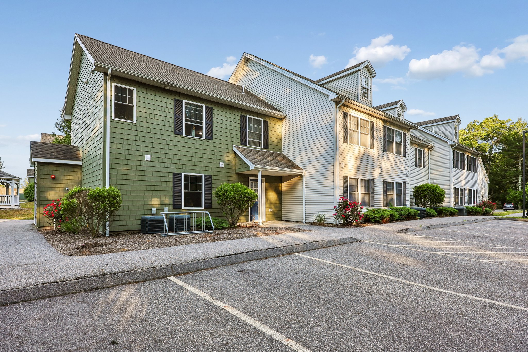 Overhead view of the Meadowbrook Gardens apartment complex in Mansfield Center, CT, showcasing multiple buildings and green spaces within the community.
