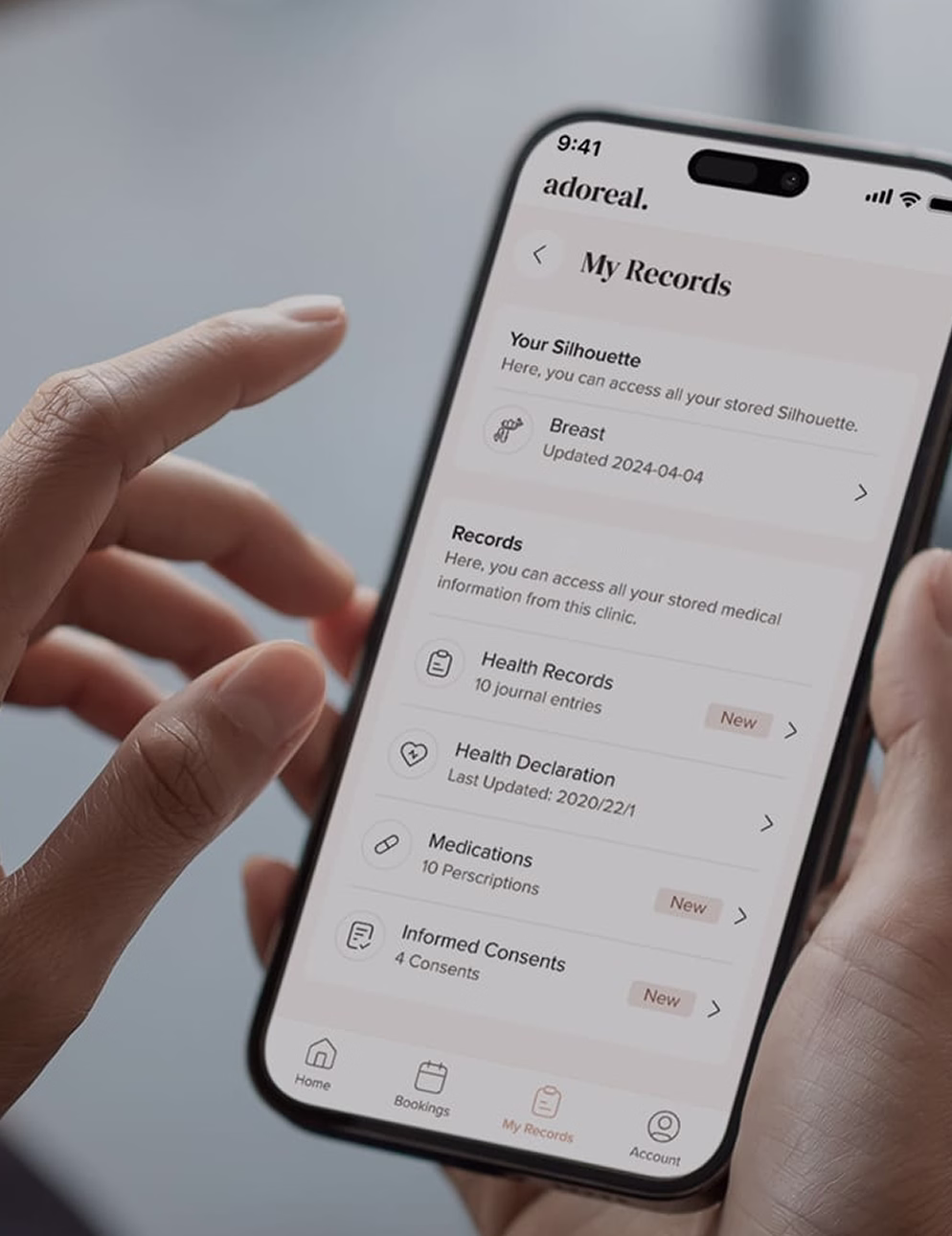 Hand holding a smartphone displaying the Adoreal app's My Records screen with health records, medications, and informed consents
