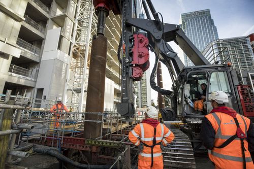 Operatives and piling machinery installing piling casings.