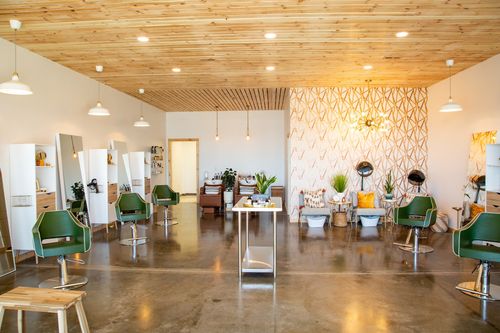 A scene of a well manicured lawn with lovely shrubbery in a flower bed from the road looking at a house