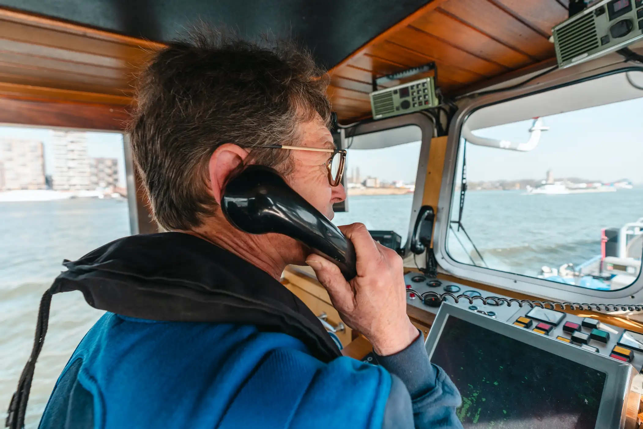 Bunkerschipper van Nobel belt in stuurhut bunkerboot