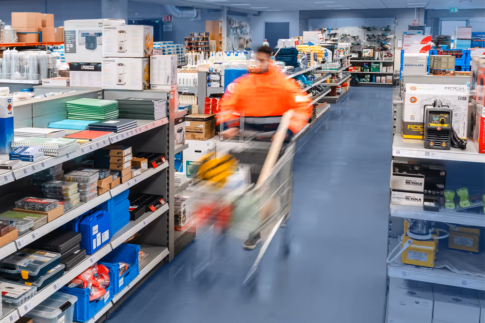 Klant loopt door de Nobel scheepswinkel met winkelwagen