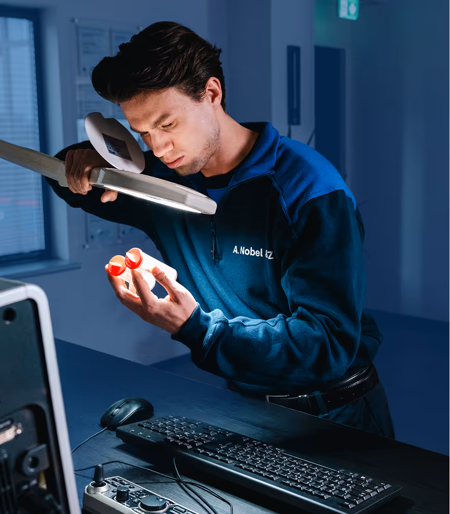 Afdeling Inspectie van Nobel inspecteert monsterflesje met bacteriƫn