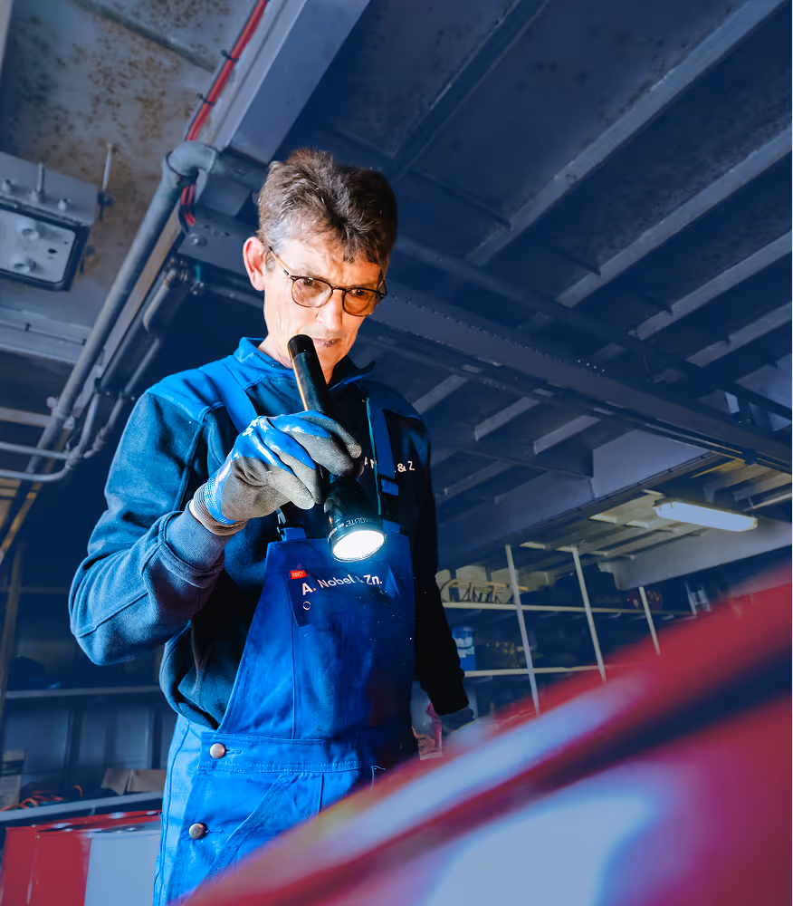 Bunkerschipper van Nobel bekijkt oliedrum met zaklamp