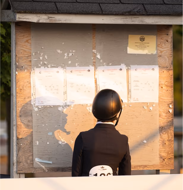 a horse rider looking at the competition course plan