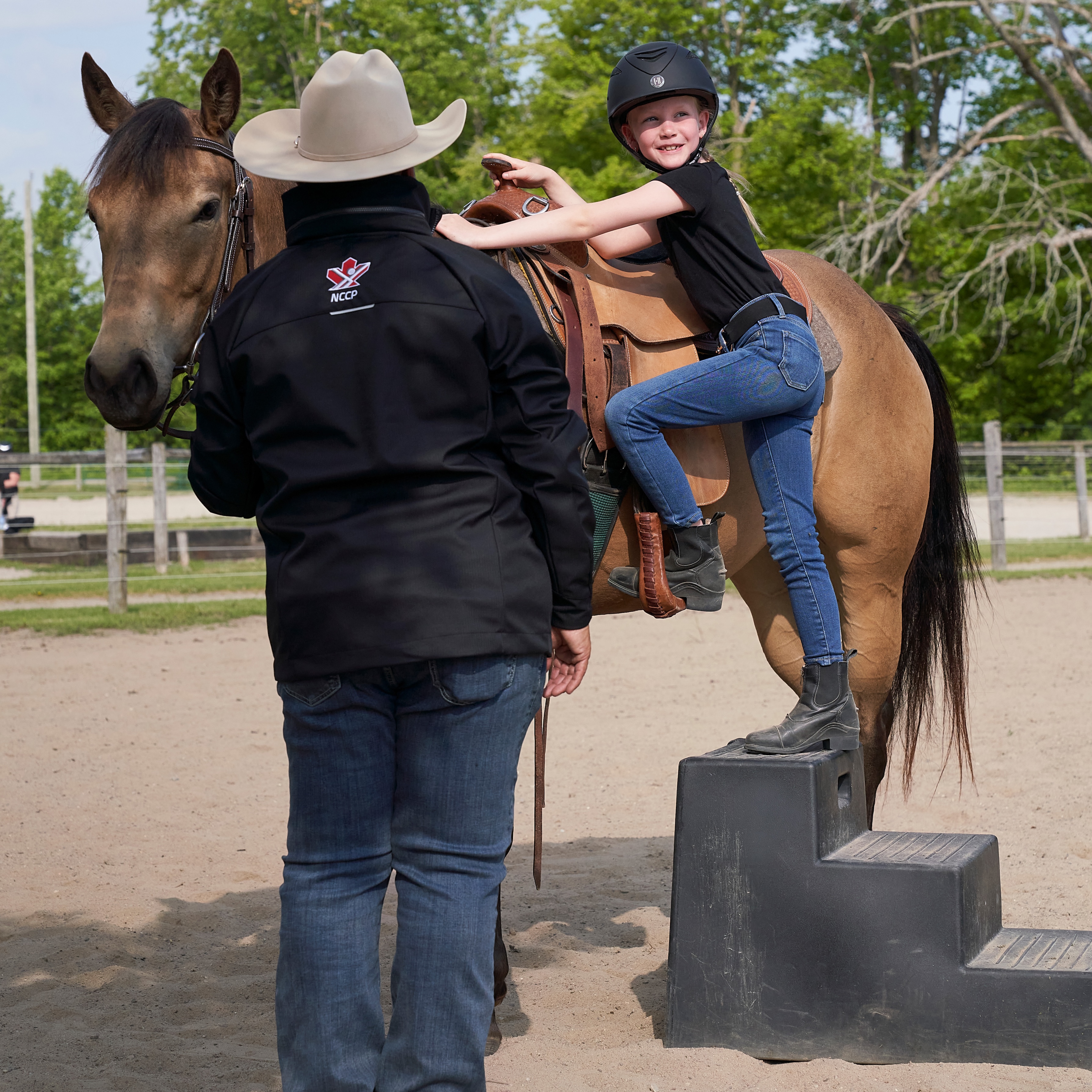 young rider getting on a horse to learn to ride.