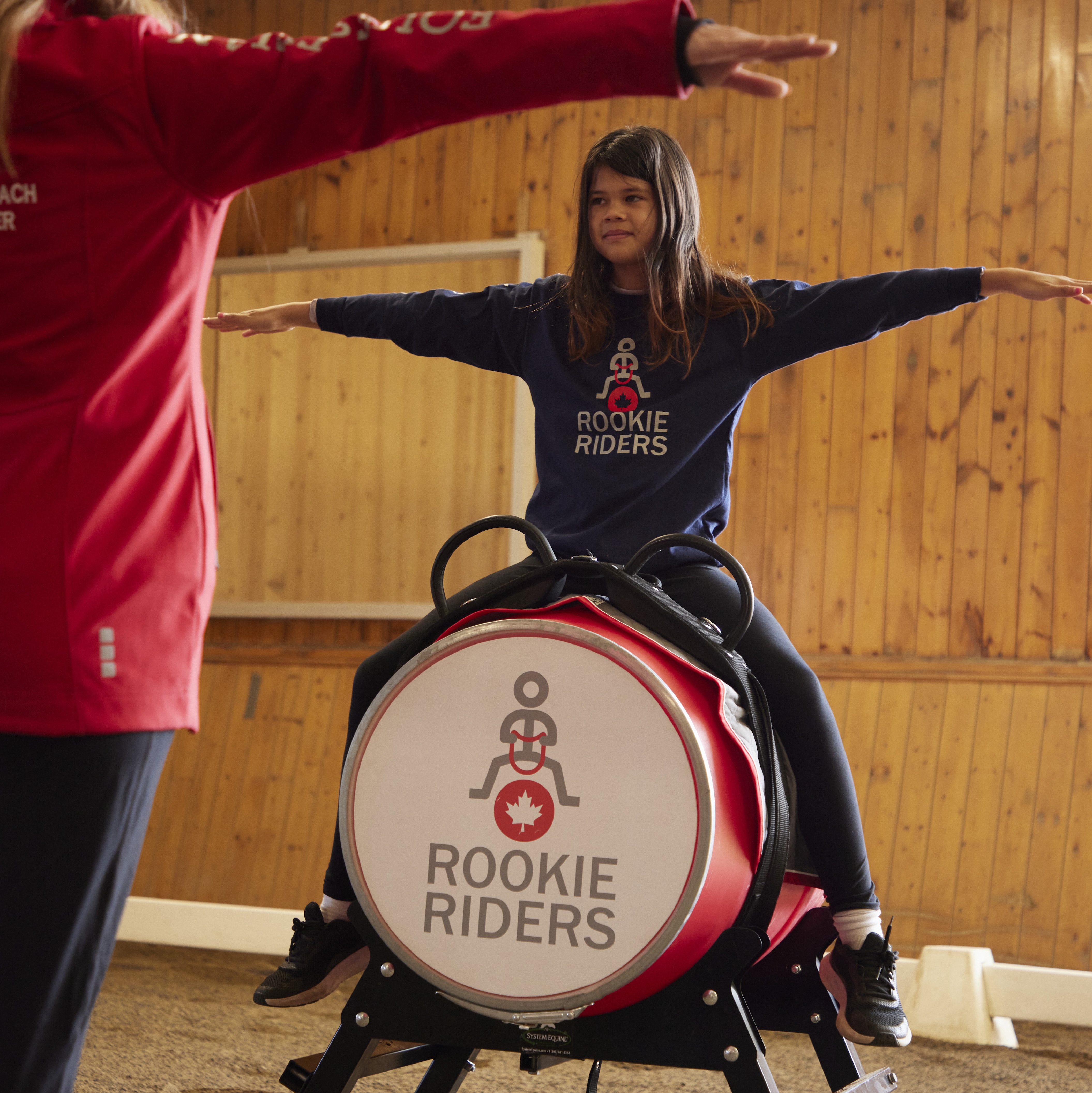 a young rider on a rookie riders barrel doing exercises