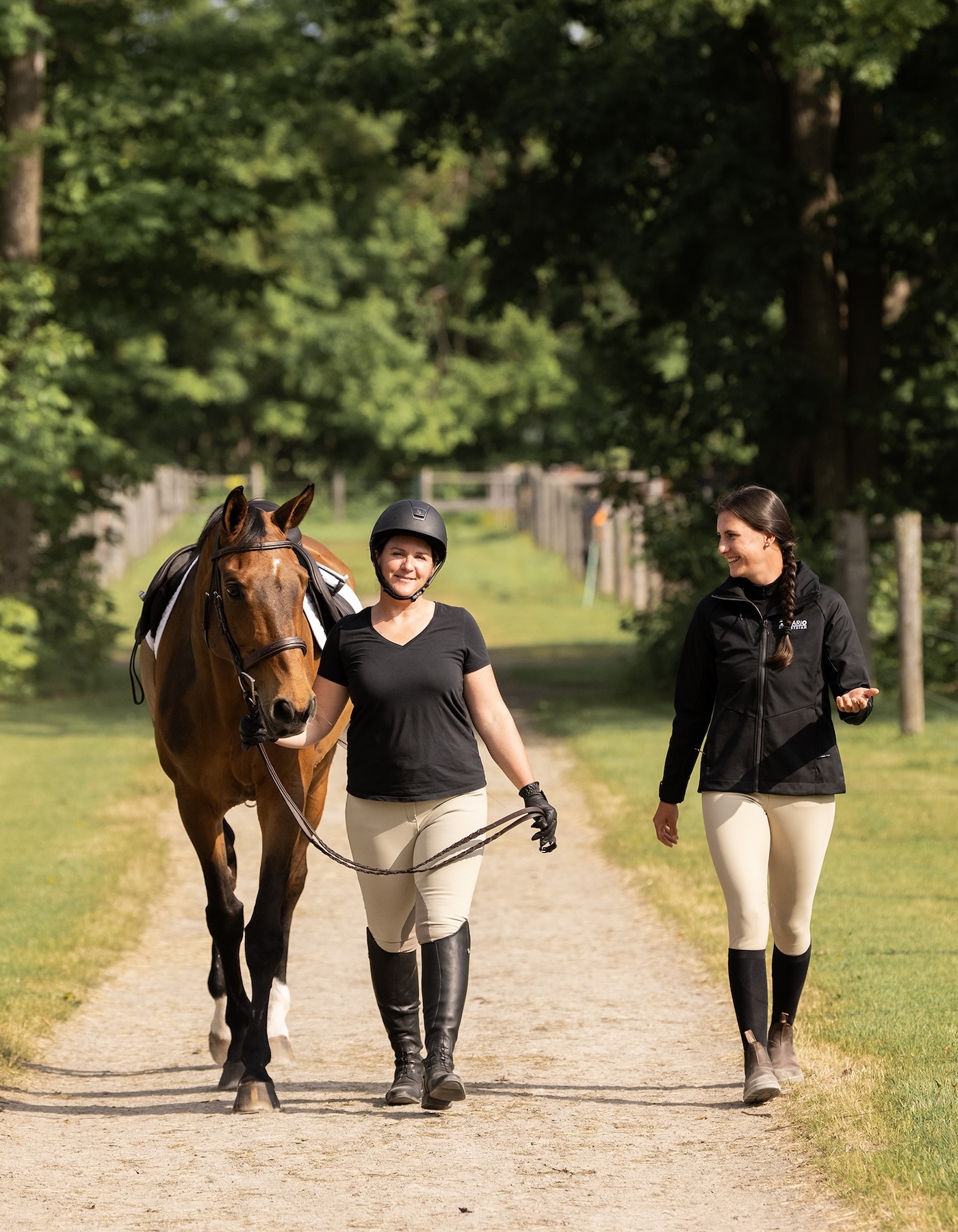 coach helping a rider fix their horse's bridle