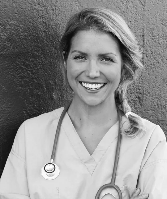 Smiling medical aesthetics professional in scrubs with a stethoscope