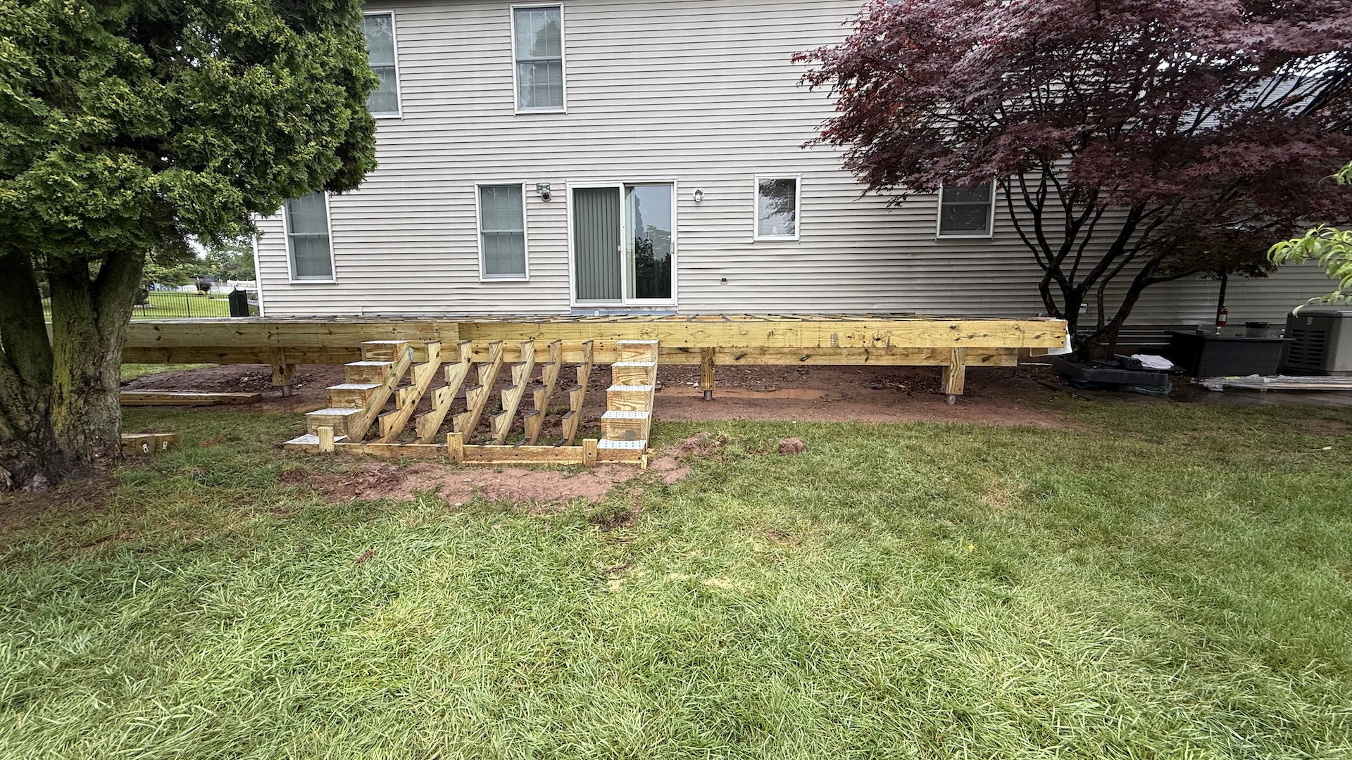 New deck framing in progress with stairs being installed