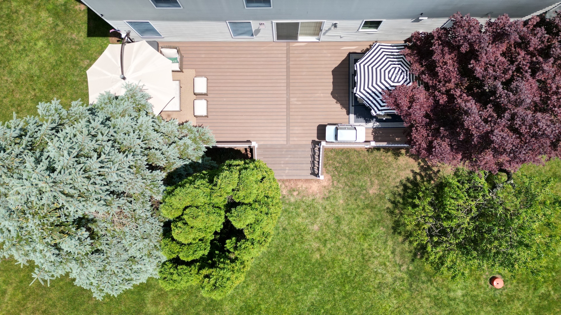 Overhead drone view of picture frame composite deck with dual umbrellas