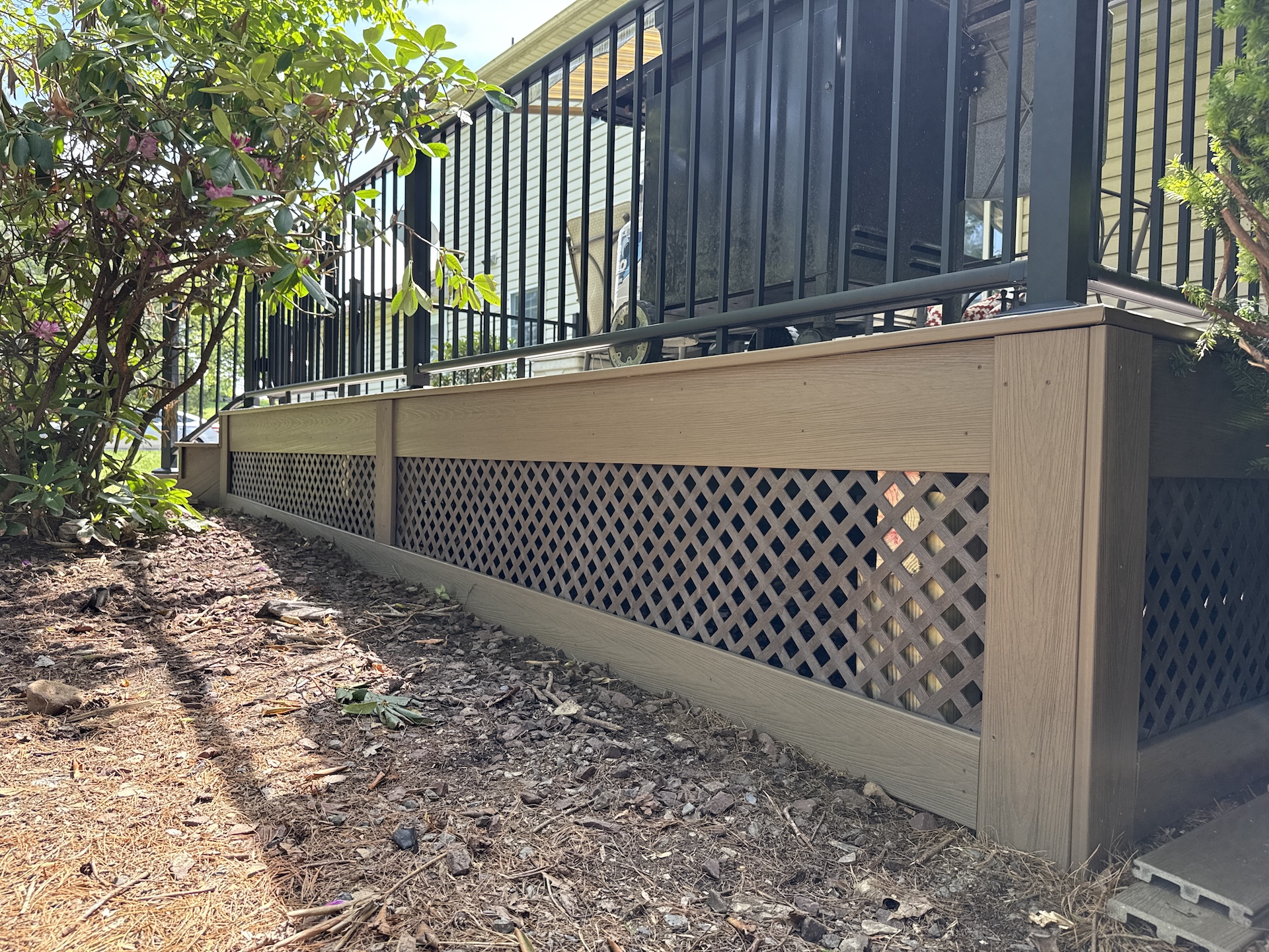 Brown lattice skirting under a raised composite deck