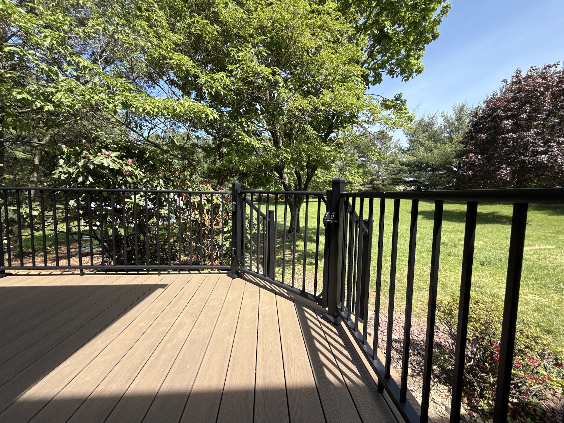 Composite deck surface with black aluminum gate and railing