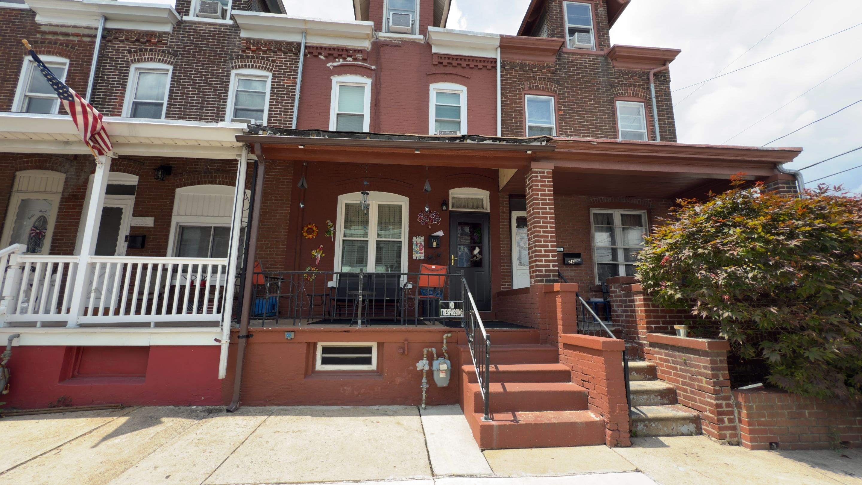 Original front porch in Allentown, PA before renovation showing worn floor and railing.