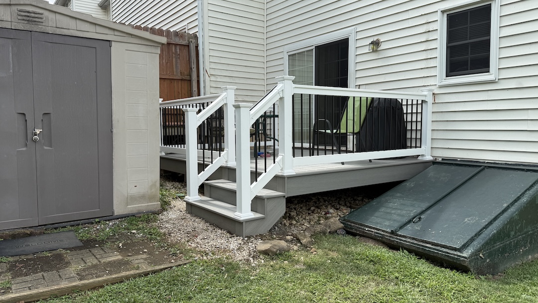 Resurfaced deck with gray composite decking, white vinyl railing, and black balusters in Easton, PA.