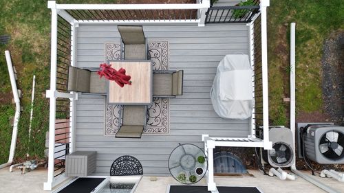 Top-down view of Saltwater composite deck with white railings, black balusters, dining table, and grill in Red Hill, PA.