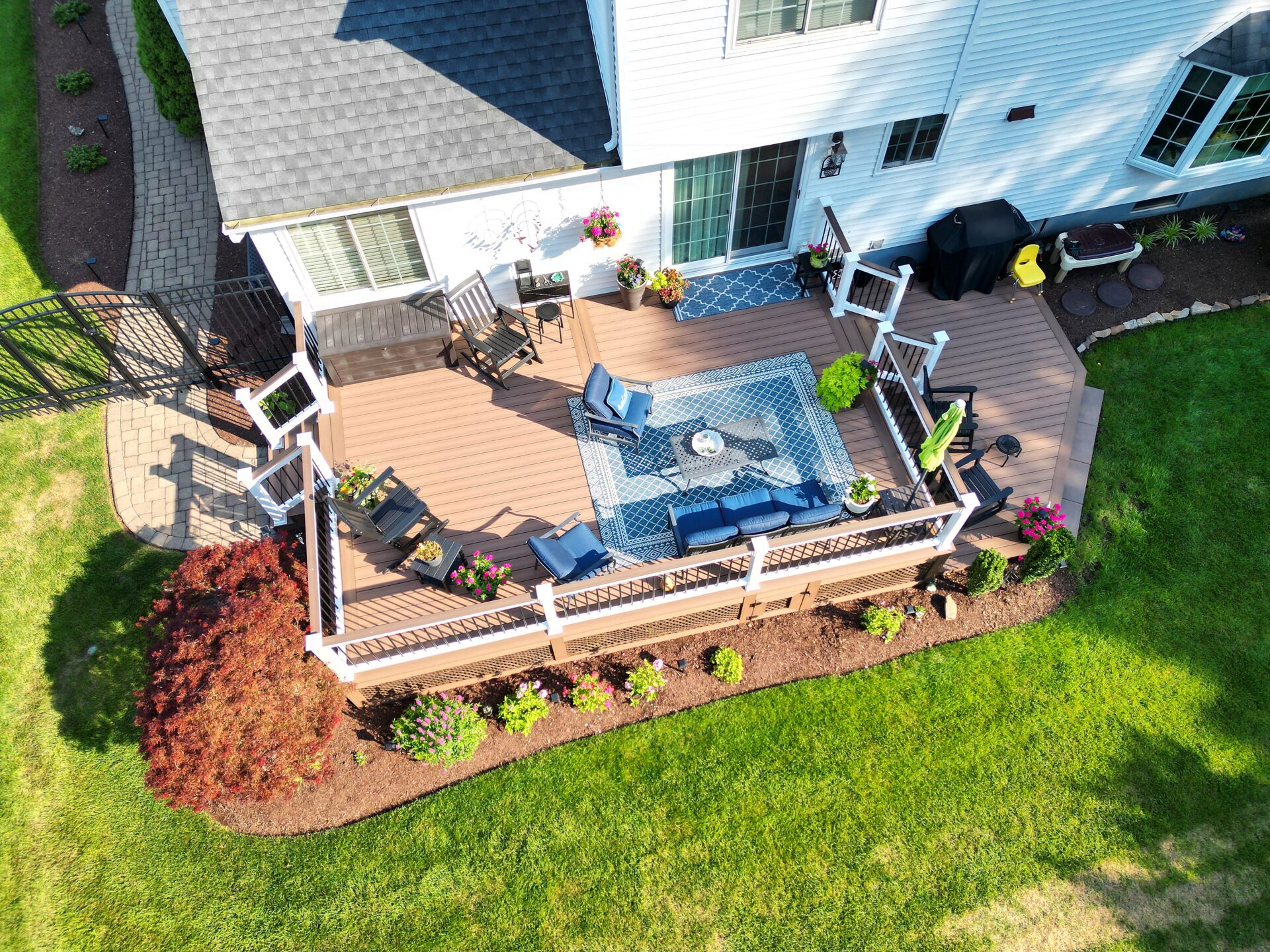 Composite deck with Deckorators Summit Boulder decking and white vinyl railing with black aluminum balusters in Piscataway, NJ.