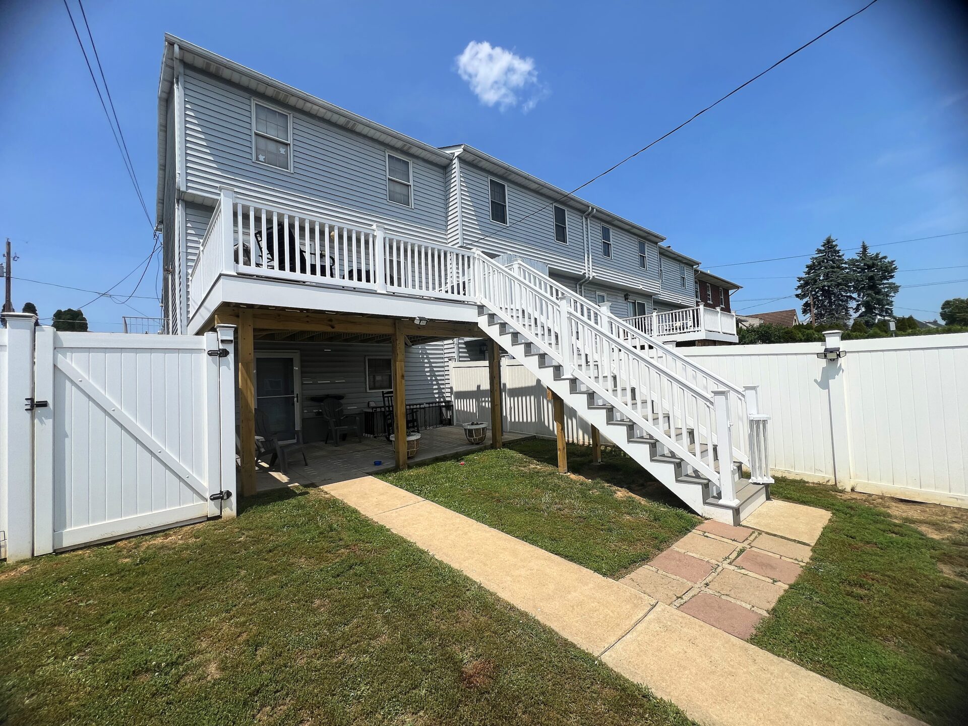 Elevated composite deck with Deckorators Venture Saltwater decking and white vinyl railing with white balusters in Northampton, PA.