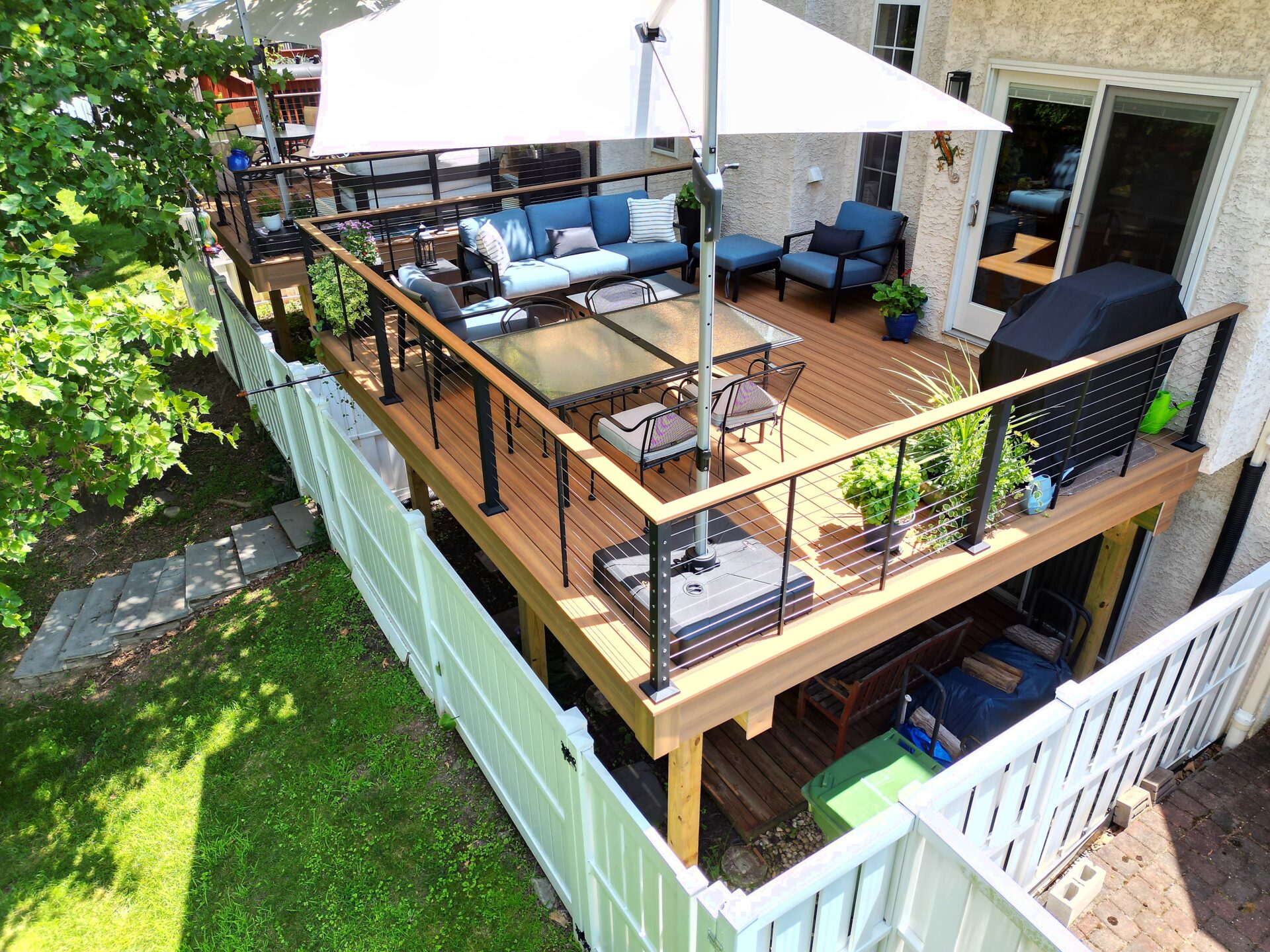 New composite deck with Deckorators Venture Sandbar decking and black aluminum railing overlooking a pond in Swedesboro, NJ.