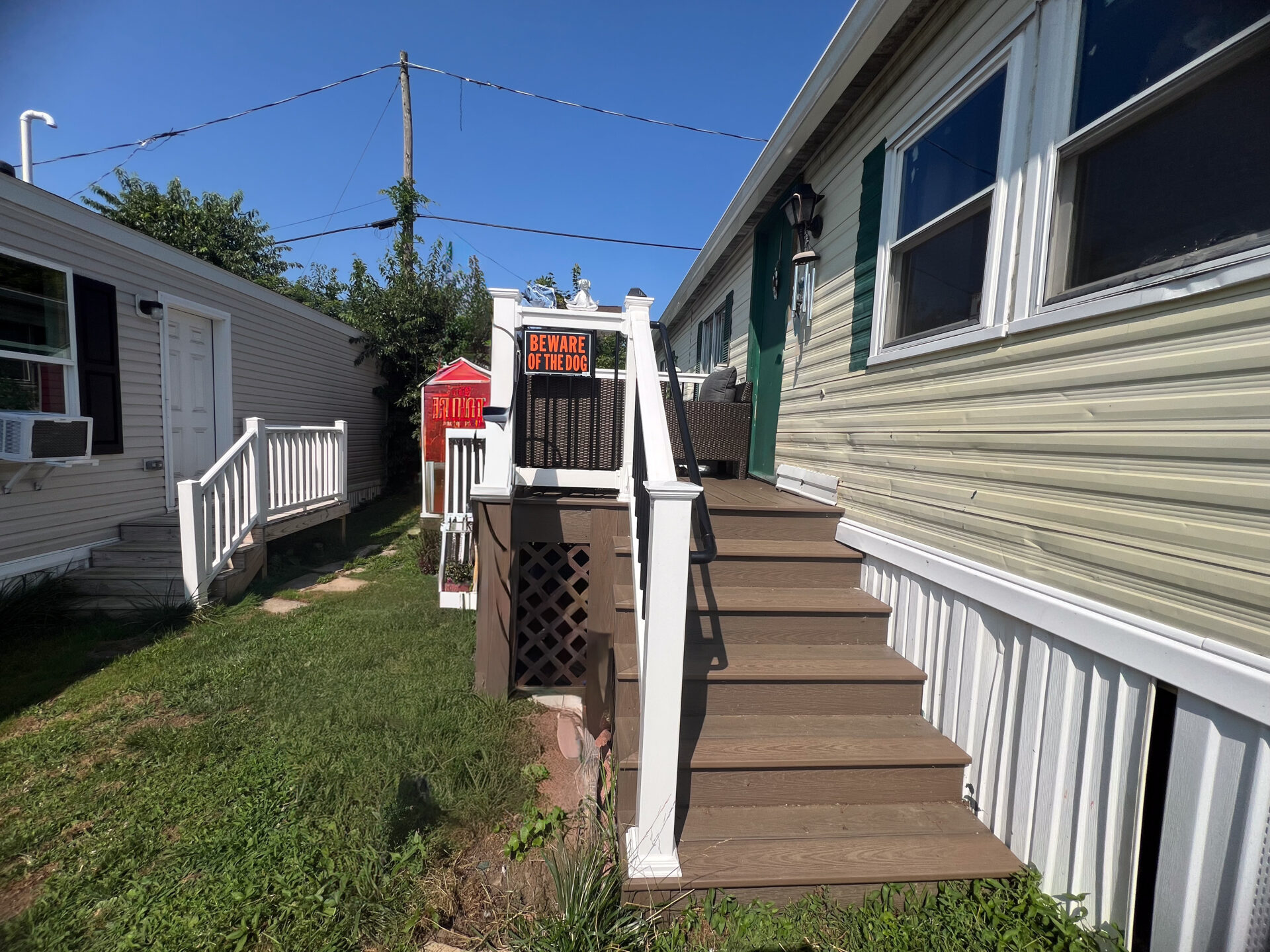New composite deck with Deckorators Venture Sandbar decking and a white vinyl railing with black aluminum balusters in Allentown, PA.