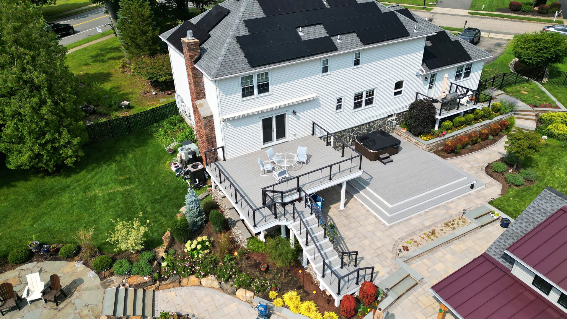 Multi-level deck with Deckorators Summit Glacier decking and horizontal cable railing overlooking a pool in Long Valley, NJ.