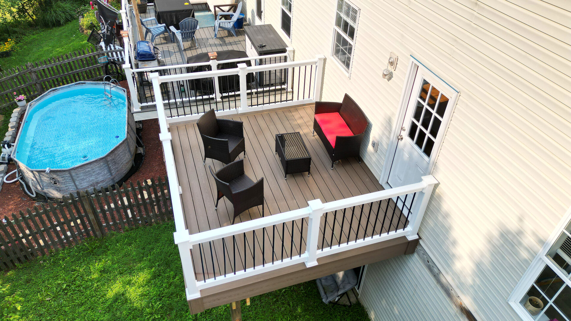 Aerial view of two resurfaced decks with grey composite decking above a backyard pool in New Tripoli, PA.