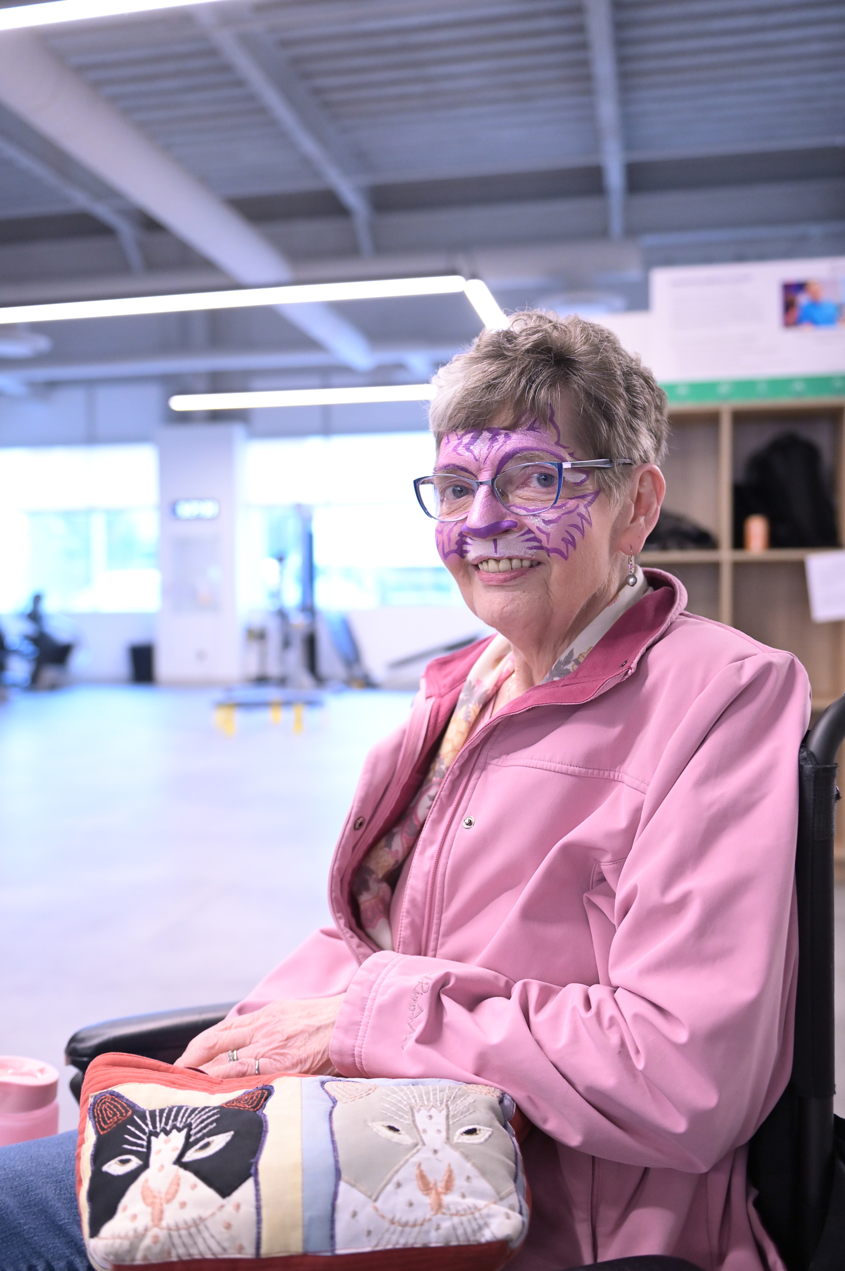 A Synaptic participant smiles while showing off purple face paint at the Client Appreciation Event.