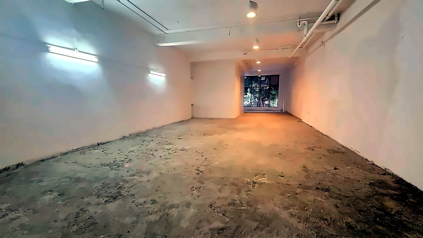 Shop for lease in Tsim Sha Tsui. Open bare-shell interior looking toward the window end.
