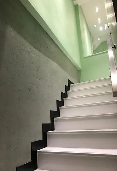 Ref#2992 features a staircase with white steps, black risers, and a light green wall 6ideal for renting office or shop space. Overhead lighting and mirrors enhance its modern, clean appeal.