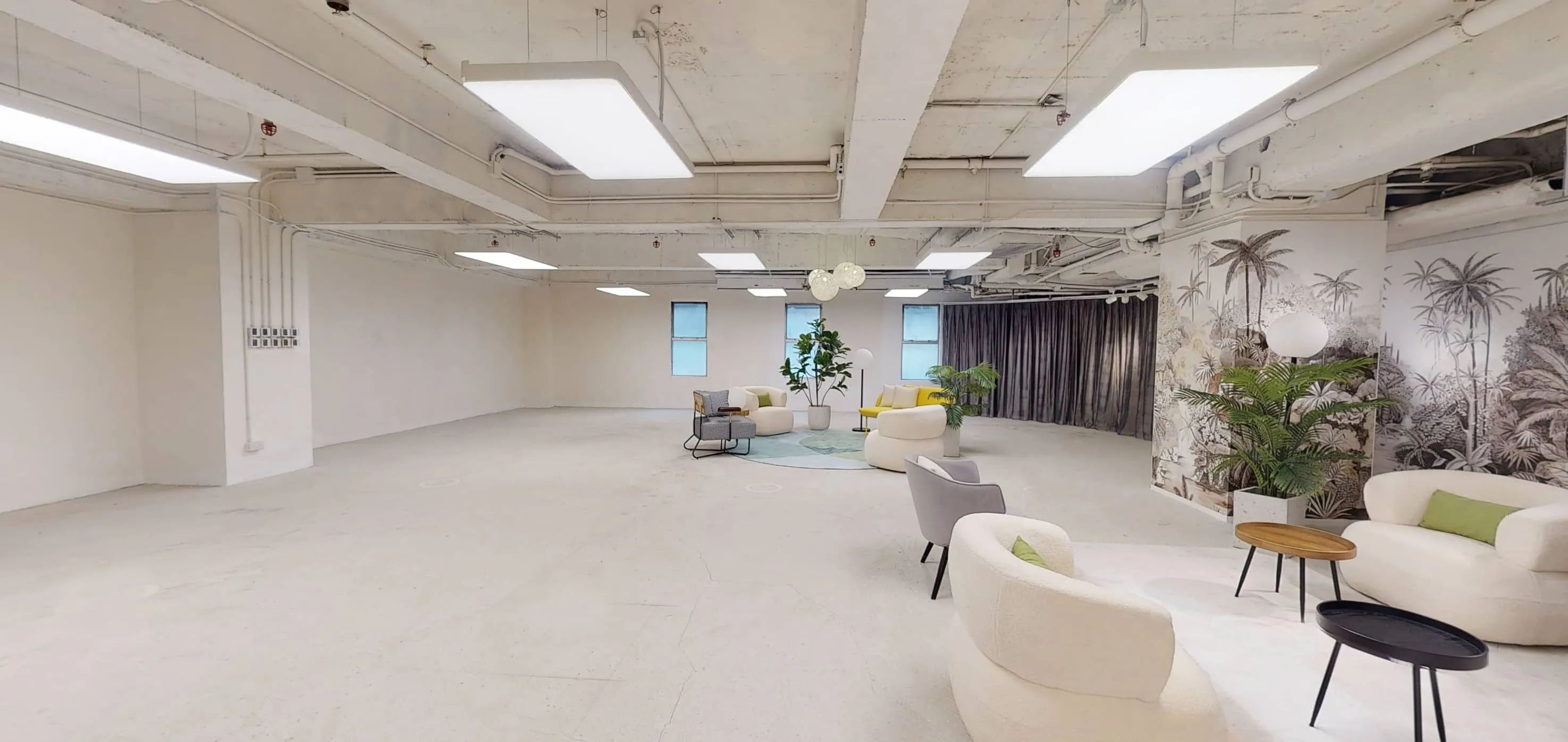 Modern room on On Hing Terrace Central with white walls lounge chairs plants and large ceiling lights.