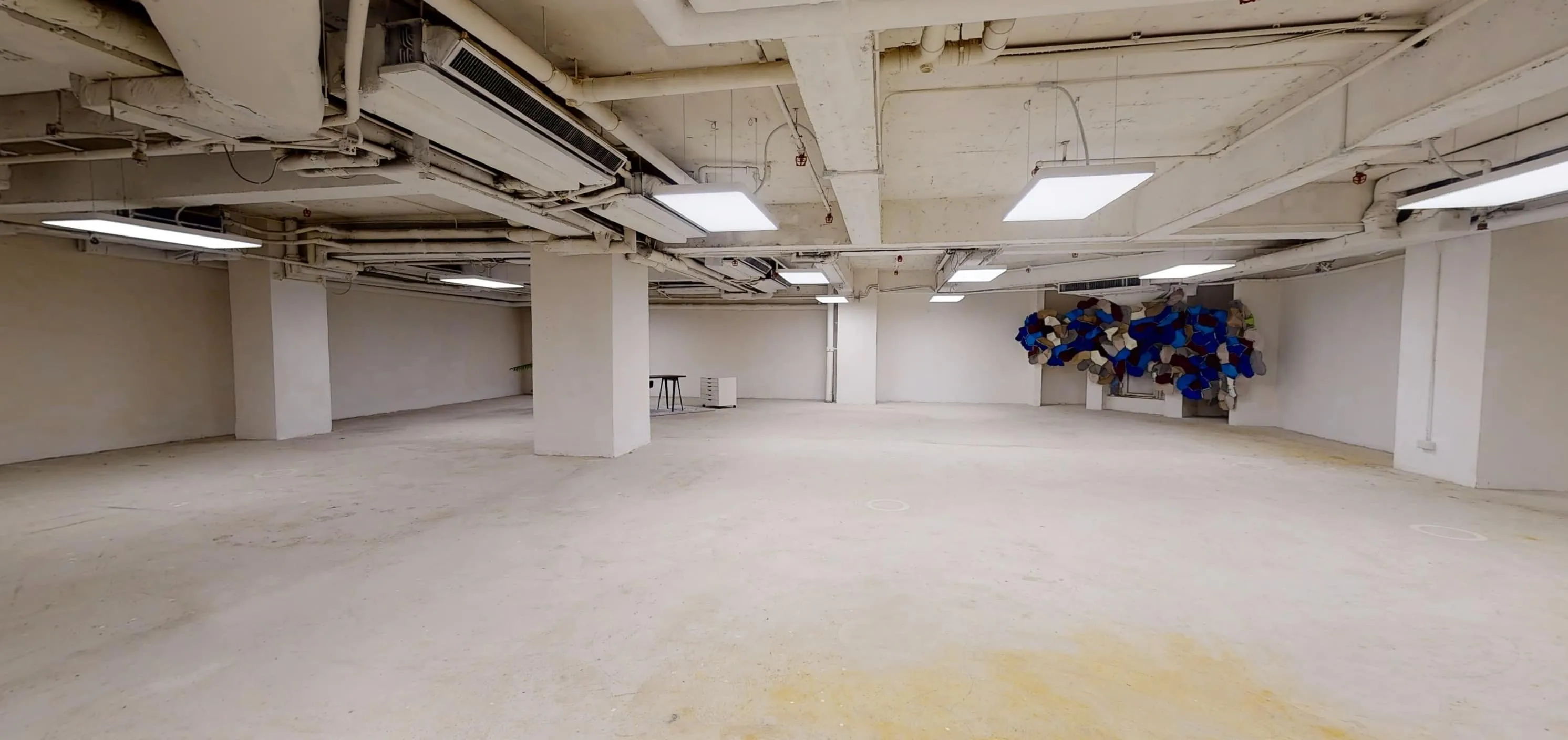 Empty white basement with columns and abstract art, located on On Hing Terrace in Central.