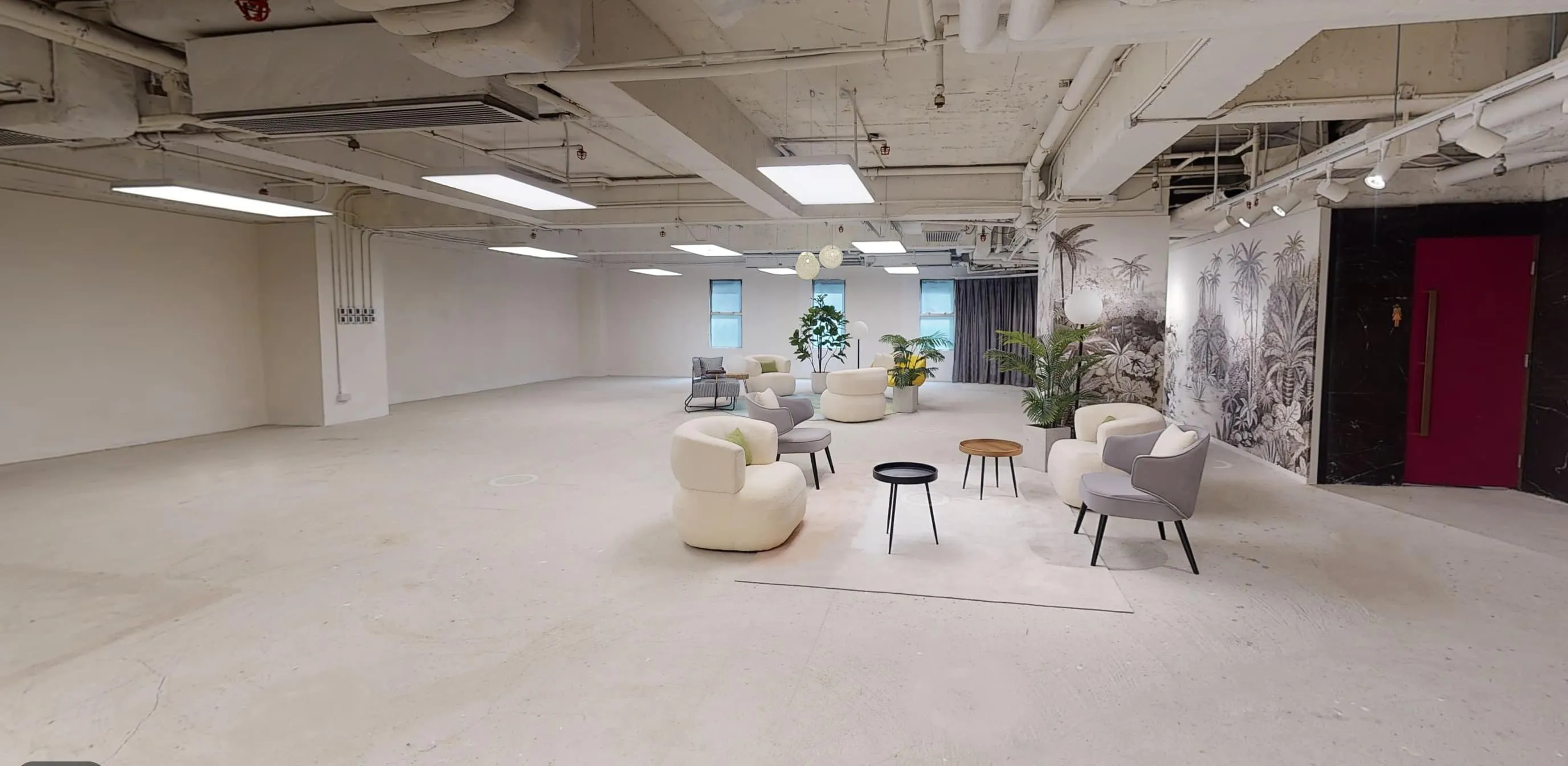 Modern room on On Hing Terrace with white walls, chairs, small tables, plants, and large ceiling lights.