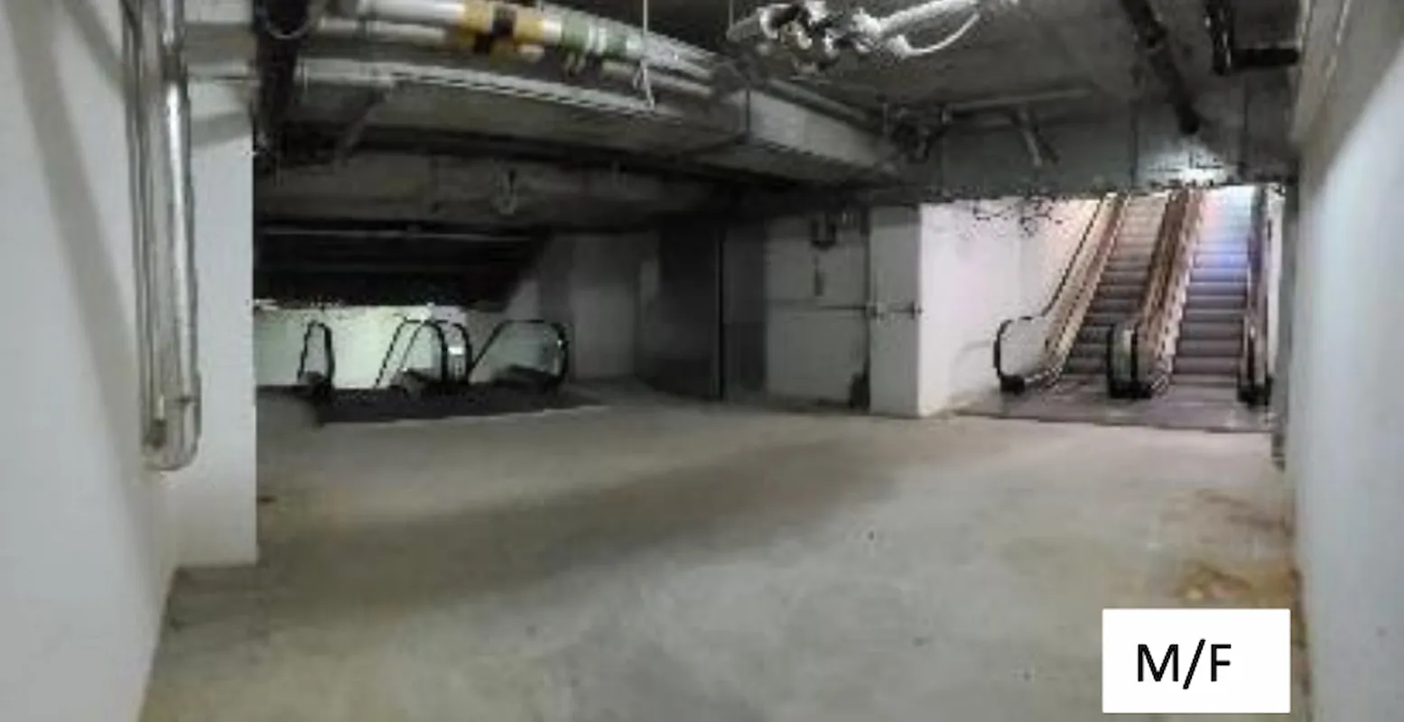 A dimly lit, empty underground space with exposed ceiling pipes and four escalators. Concrete floors suggest potential to rent shop or office. A white box labeled Ref#3011 marked M/F is seen at the bottom right.